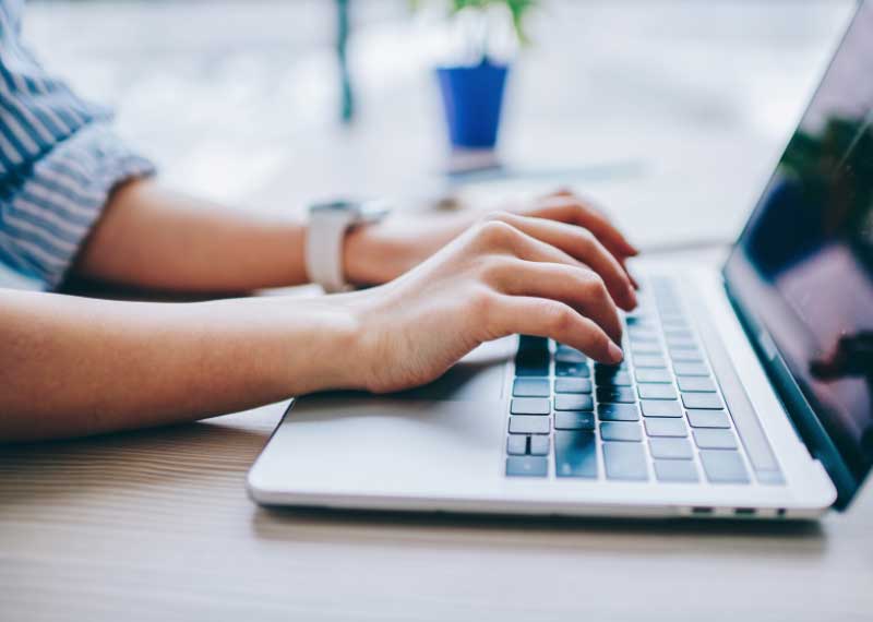 person typing on a laptop at a desk